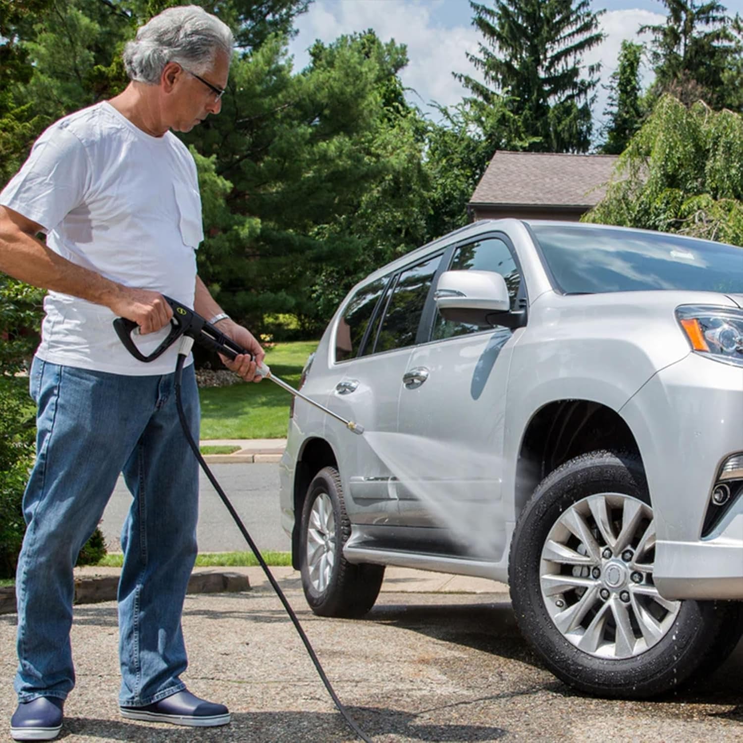 Man using car washing pressure washer to clean a car